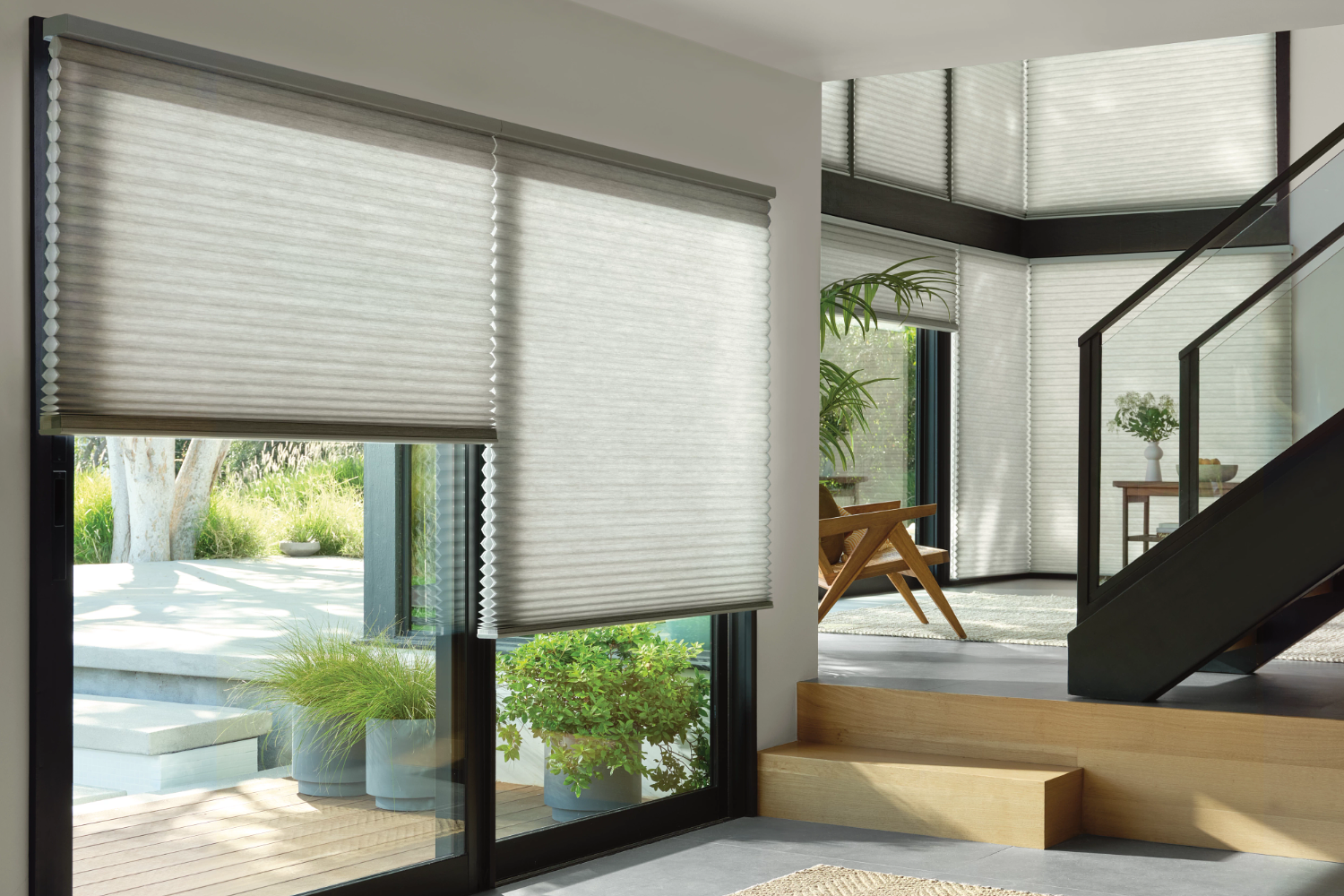 Light filtering cellular honeycomb shades installed on large patio doors and staircase windows.